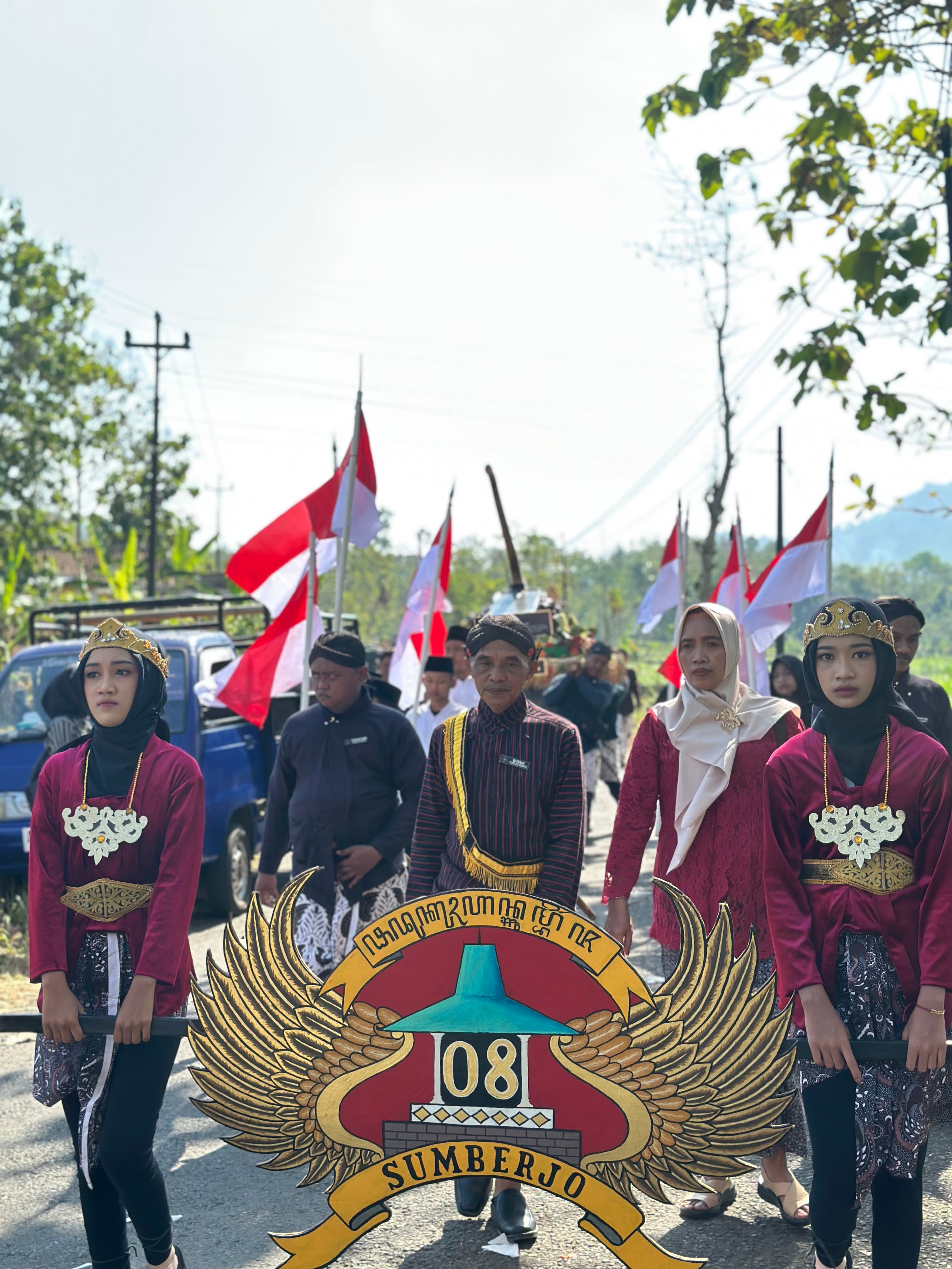 Peserta arak-arakan Rasulan membawa lambang Sumberjo